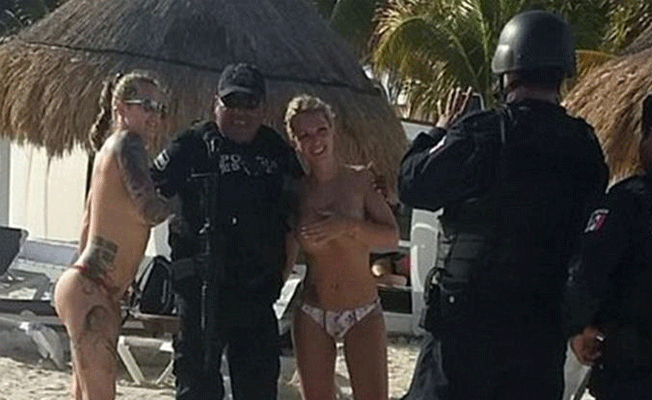 Üstsüz turistlerle çekilen fotoğraf polisleri yaktı