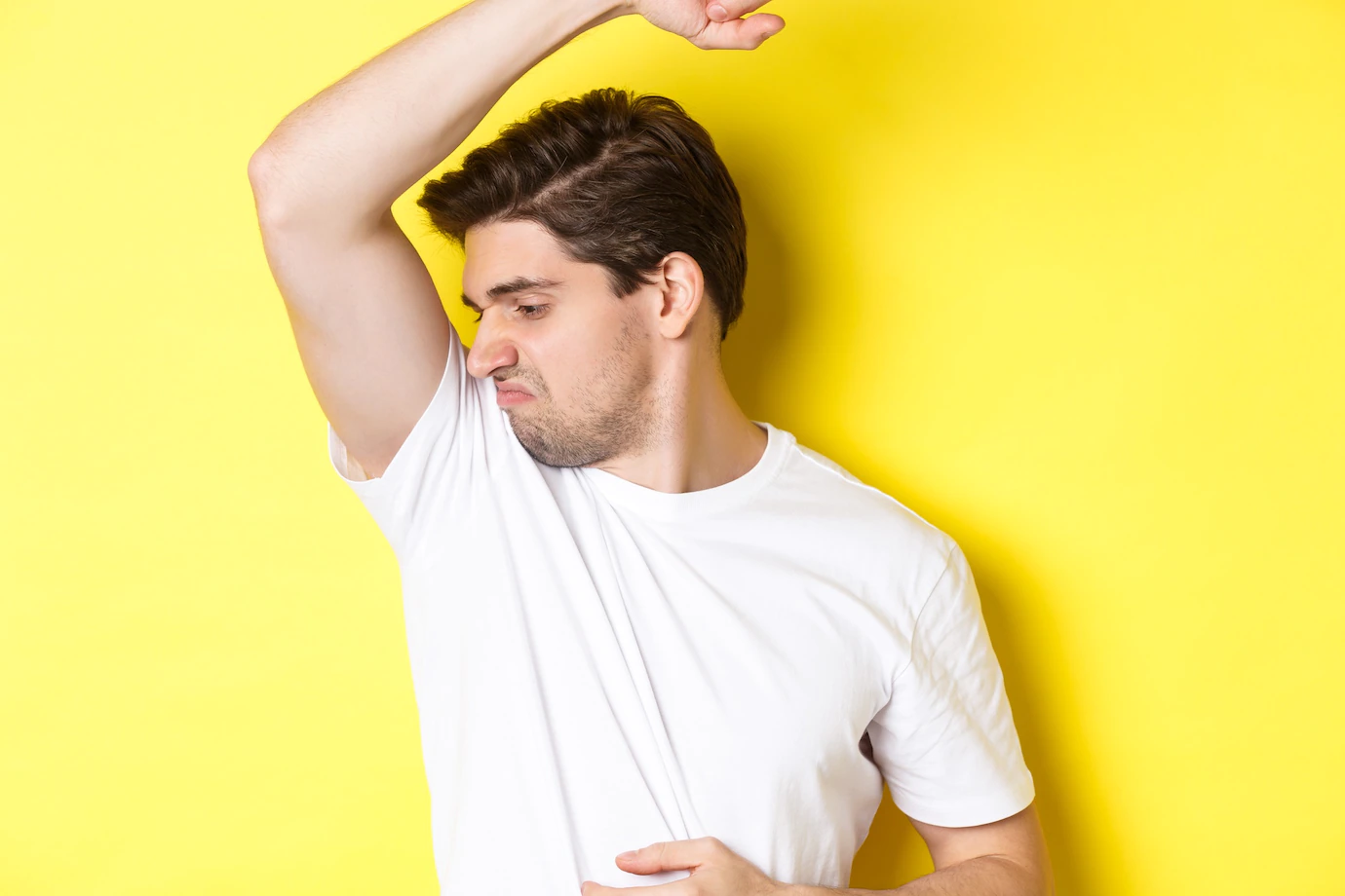 man-sweat-smelling-his-armpit-standing-white-t-shirt-grimacing-from-stinky-clothes-1258-41065.webp