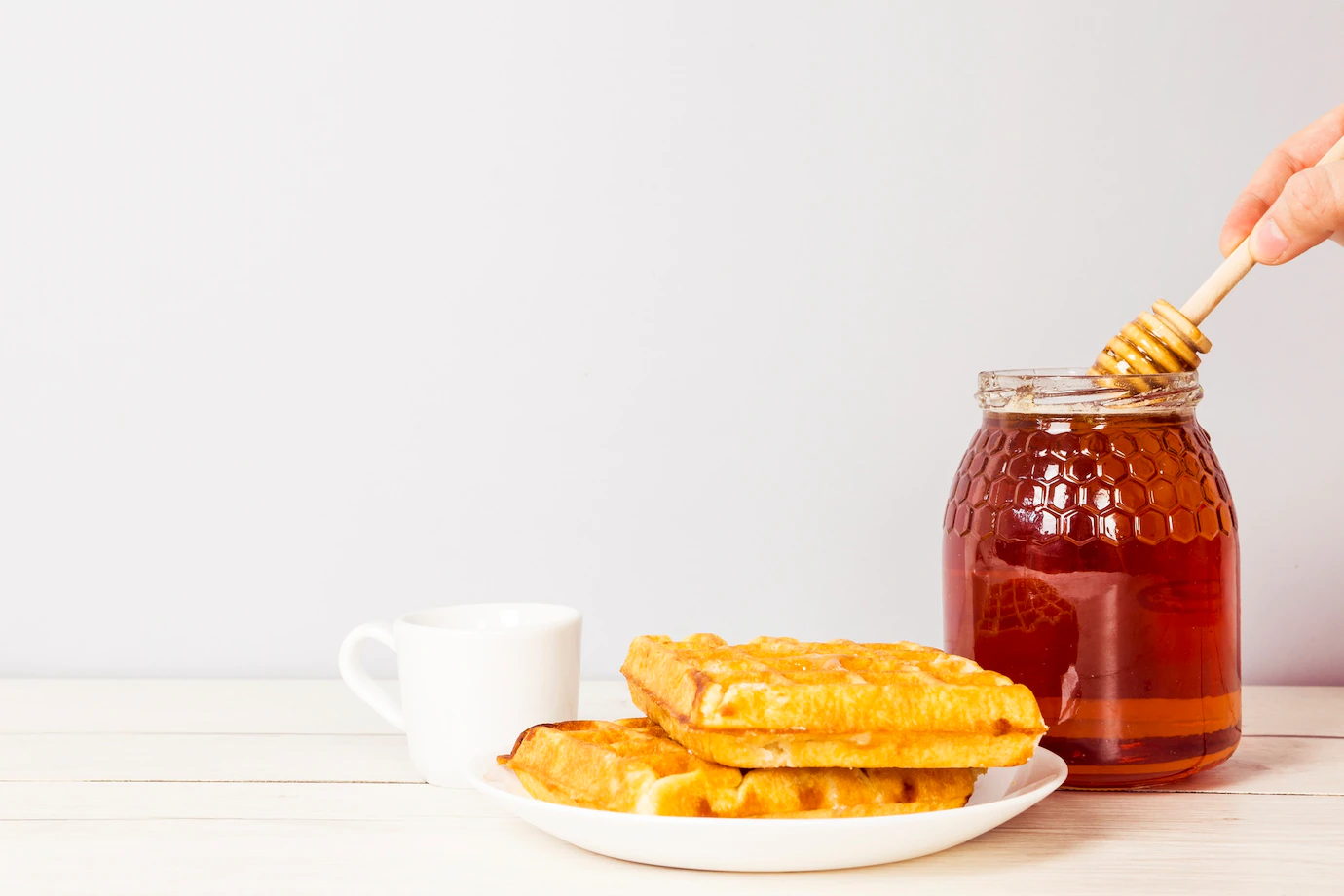 hand-holding-honey-dipper-from-jar-honey-delicious-breakfast-table-23-2148188941.webp