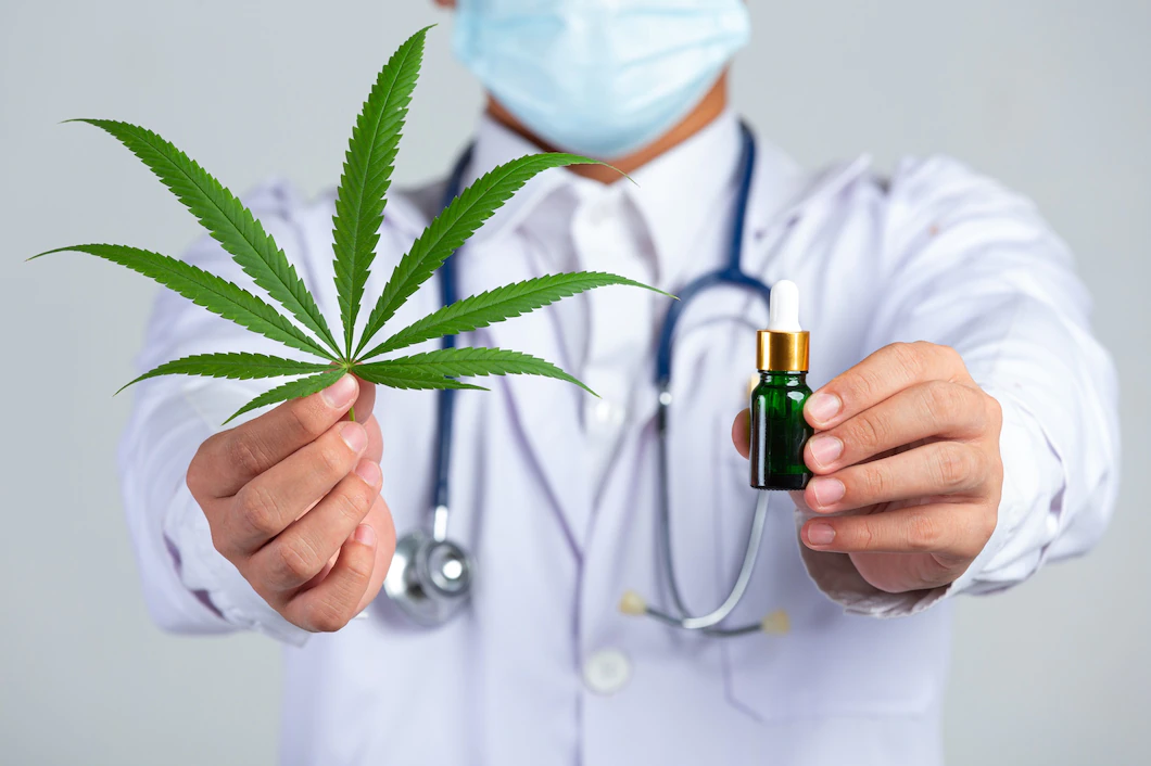 medical-doctor-holding-cannabis-leaf-bottle-cannabis-oil-white-wall-1150-26701.webp