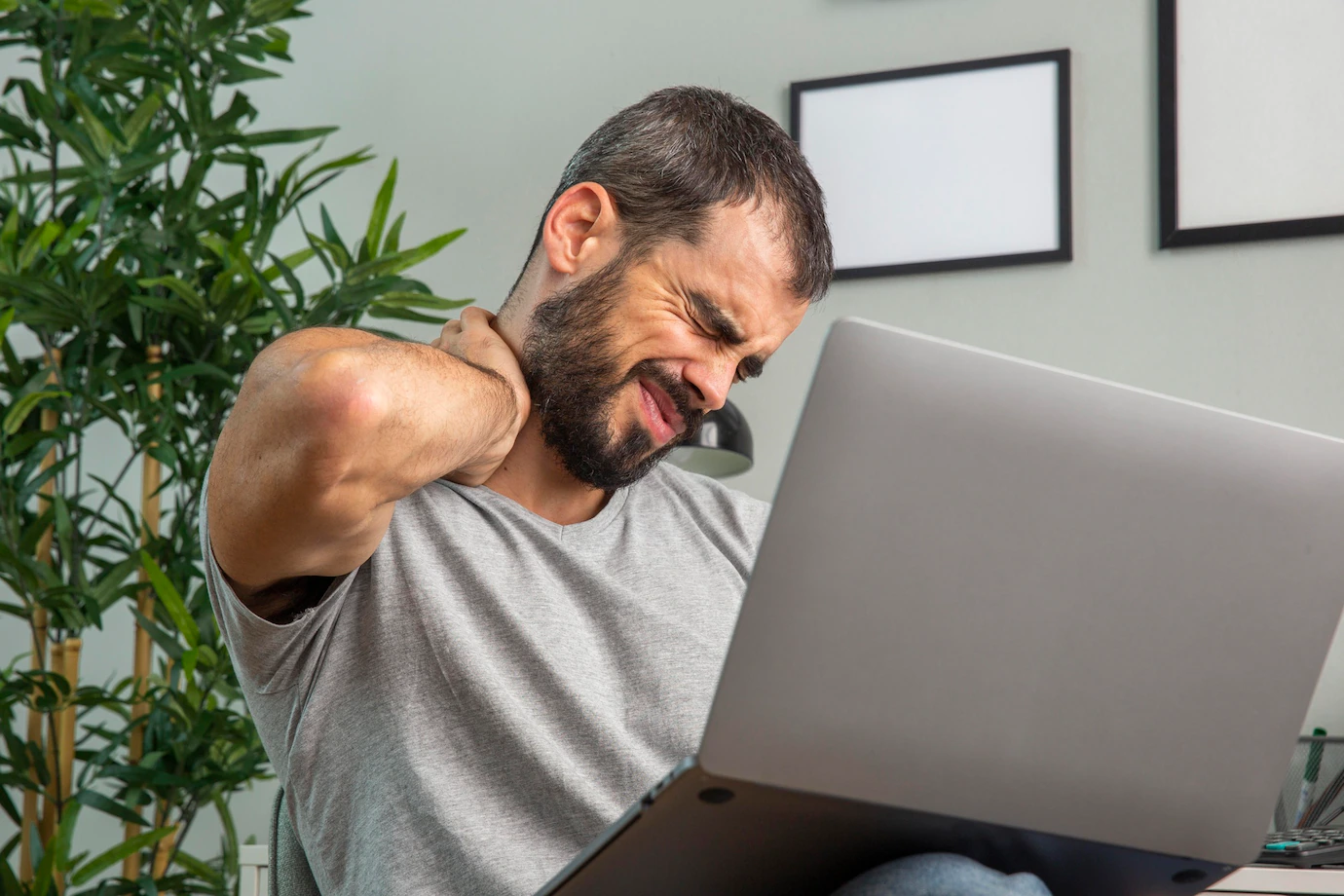 man-experiencing-neck-pain-while-working-from-home-laptop-23-2148806670.webp