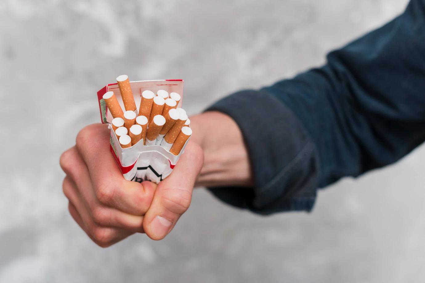 close-up-man-s-hand-crushing-cigarettes-box-23-2148185334.webp