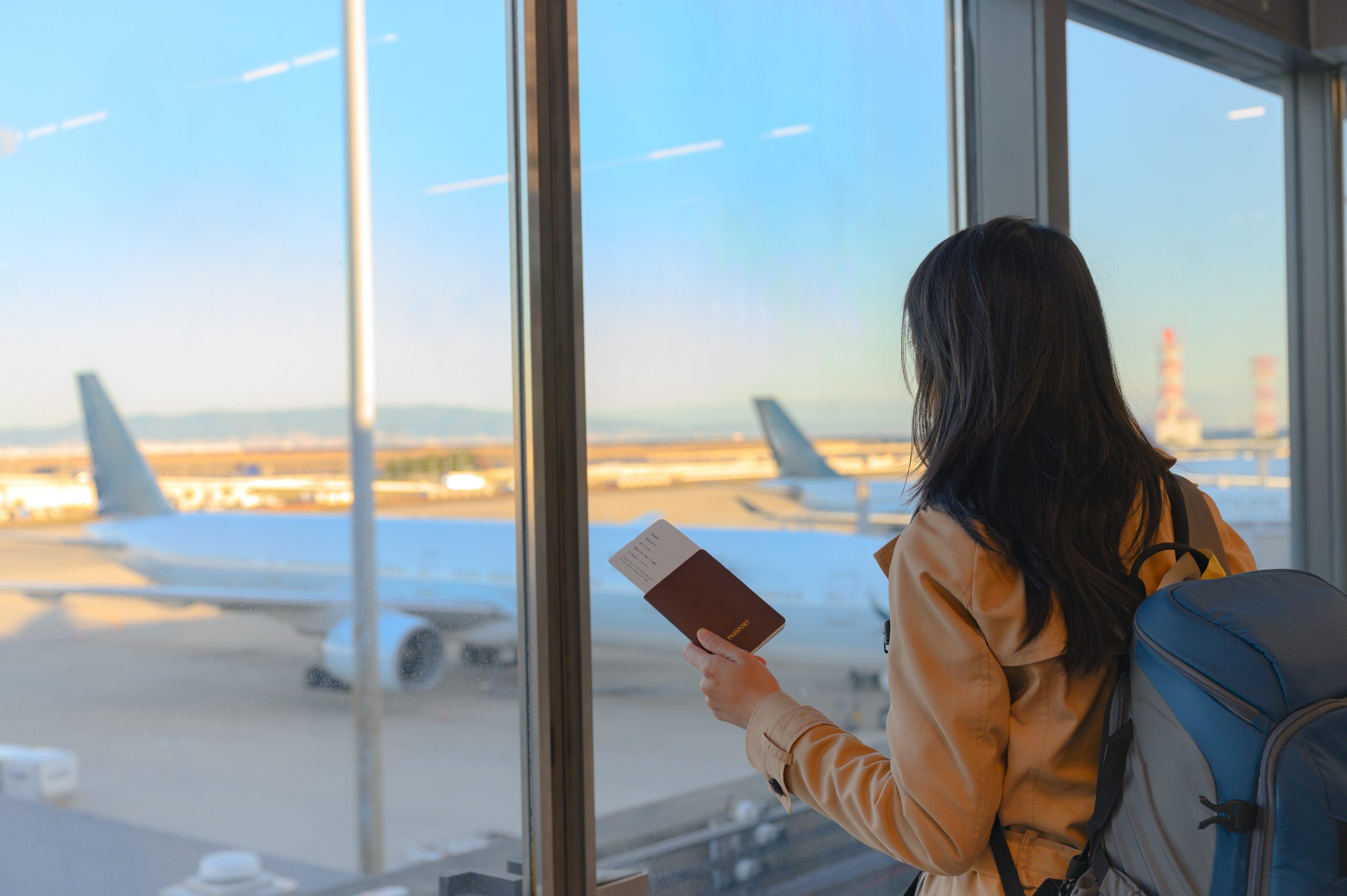 passenger-tourist-holding-passport-and-boarding-pass-waiting-for-transit-scaled.jpg
