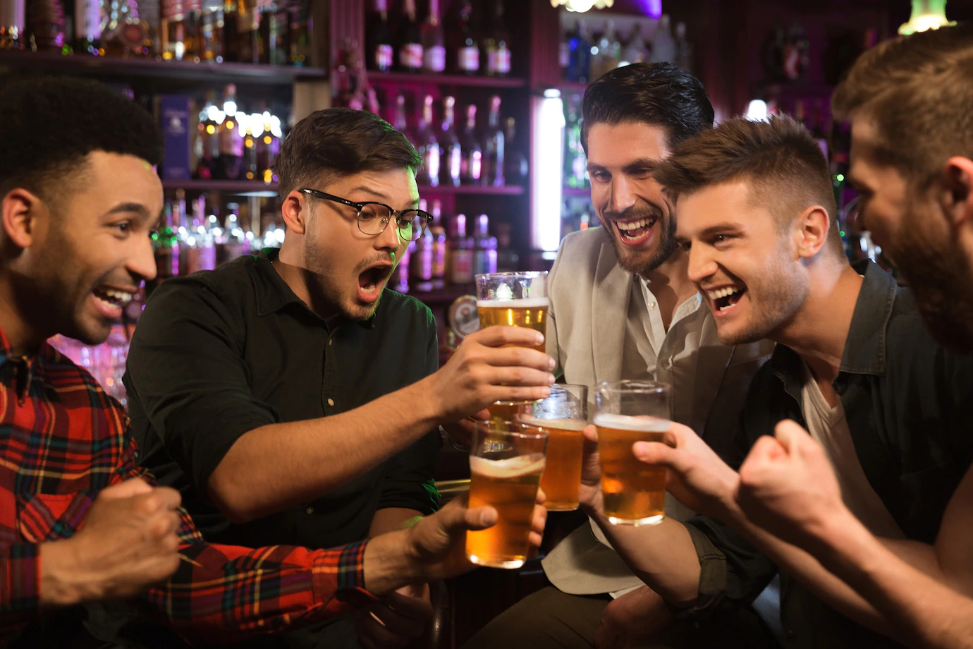 happy-male-friends-clinking-with-beer-mugs-pub-171337-13495.webp