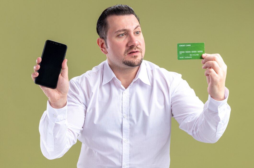 surprised-adult-slavic-businessman-holding-phone-looking-credit-card-141793-129656.jpg