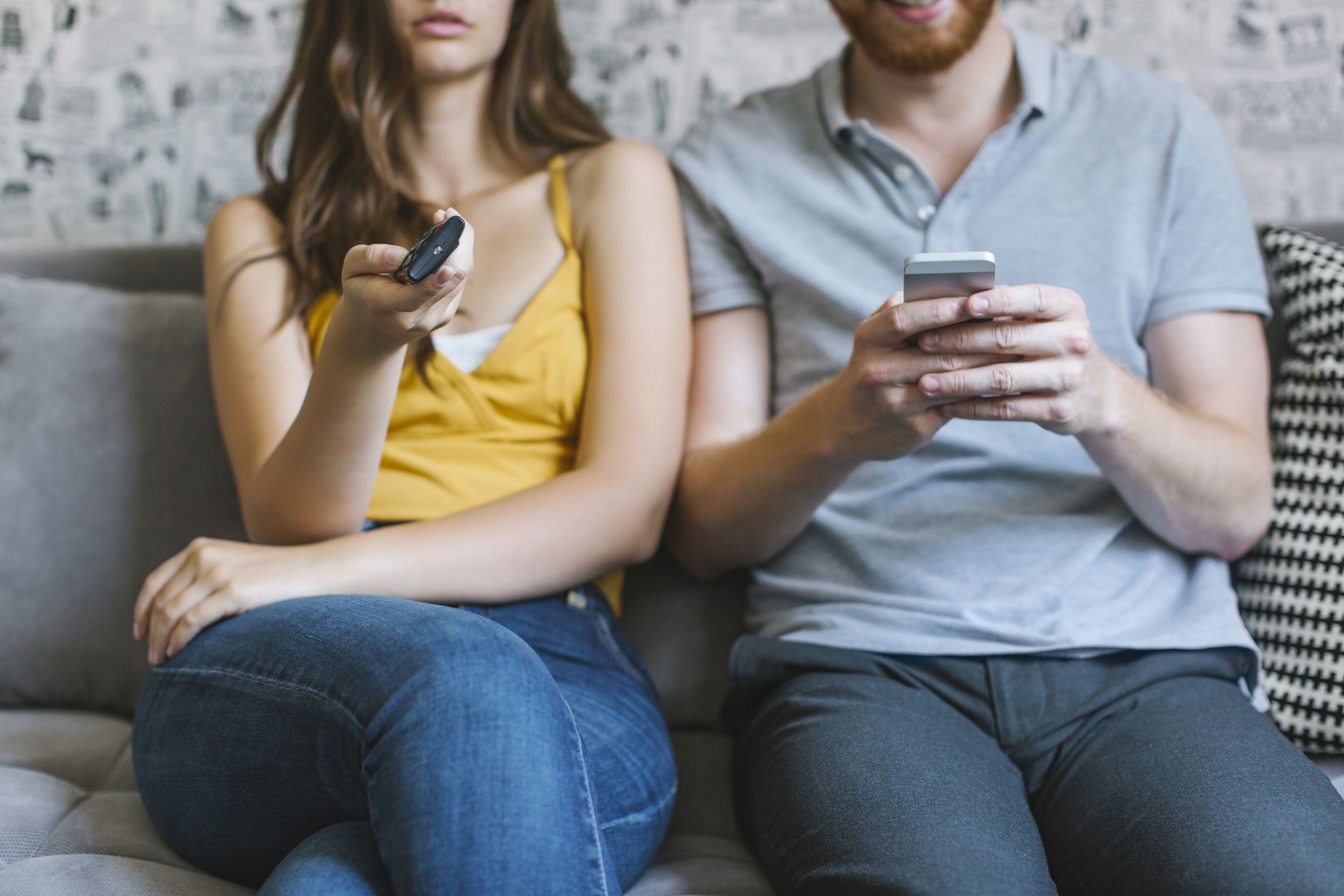 couple-sitting-on-couch-with-remote-control-and-royalty-free-image-1032826724-1545922227.jpg