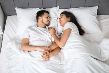 230737303-loving-young-couple-lying-in-bed-at-home-top-view.jpg