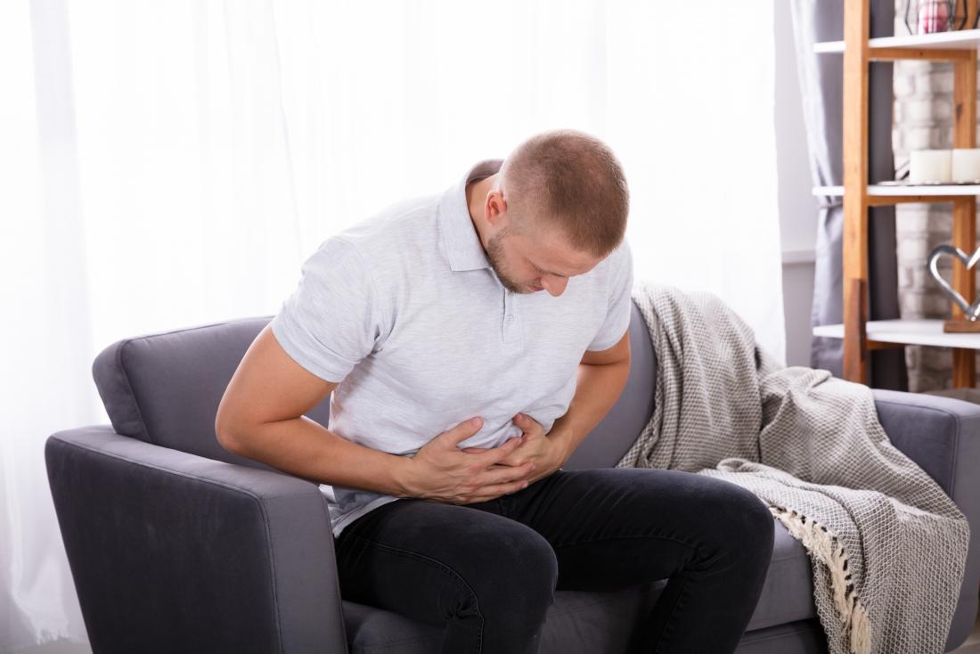 man-sitting-on-sofa-holding-his-stomach-in-pain.jpg