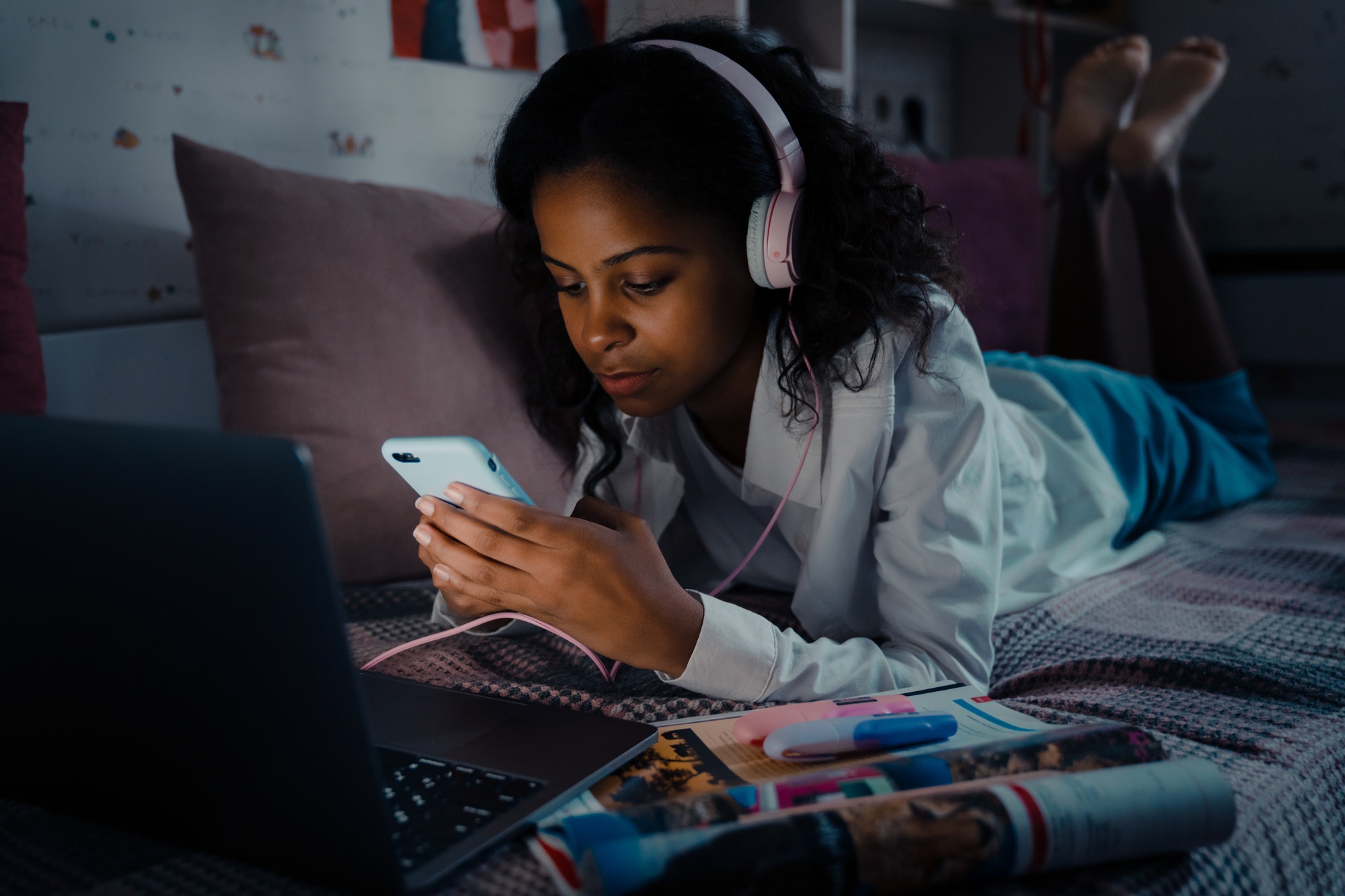 african-calm-teen-girl-in-headphones-scrolling-social-media.jpg