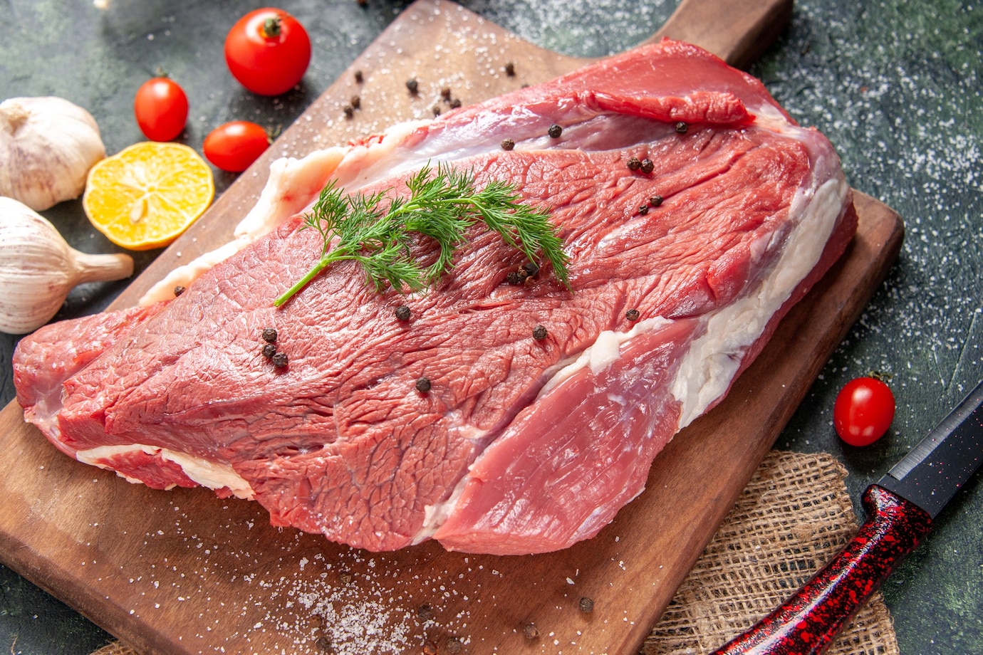 front-view-fresh-raw-red-meat-wooden-cutting-board-nude-color-towel-lemon-garlic-mixed-color-background-179666-47409.jpg