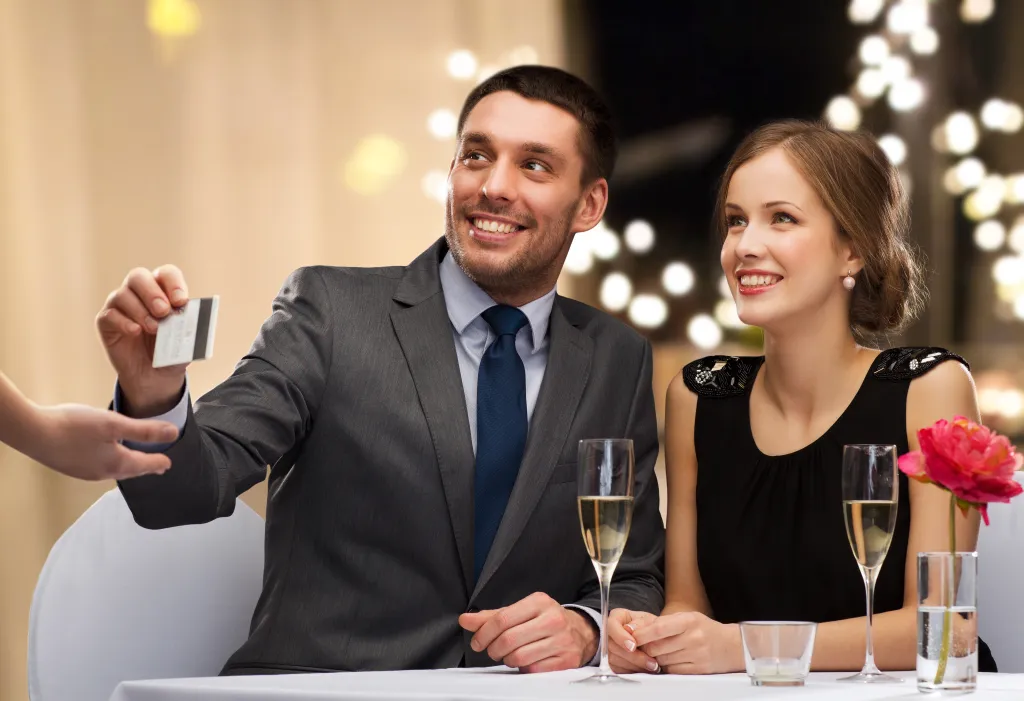 happy-couple-restaurant-paying-credit-92887912.webp