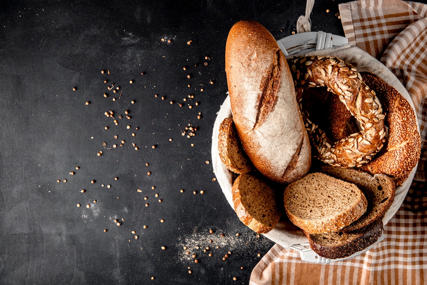 top-view-basket-full-breads-as-baguette-bagel-rye-with-sunflower-seeds-black-surface-141793-1541.jpg