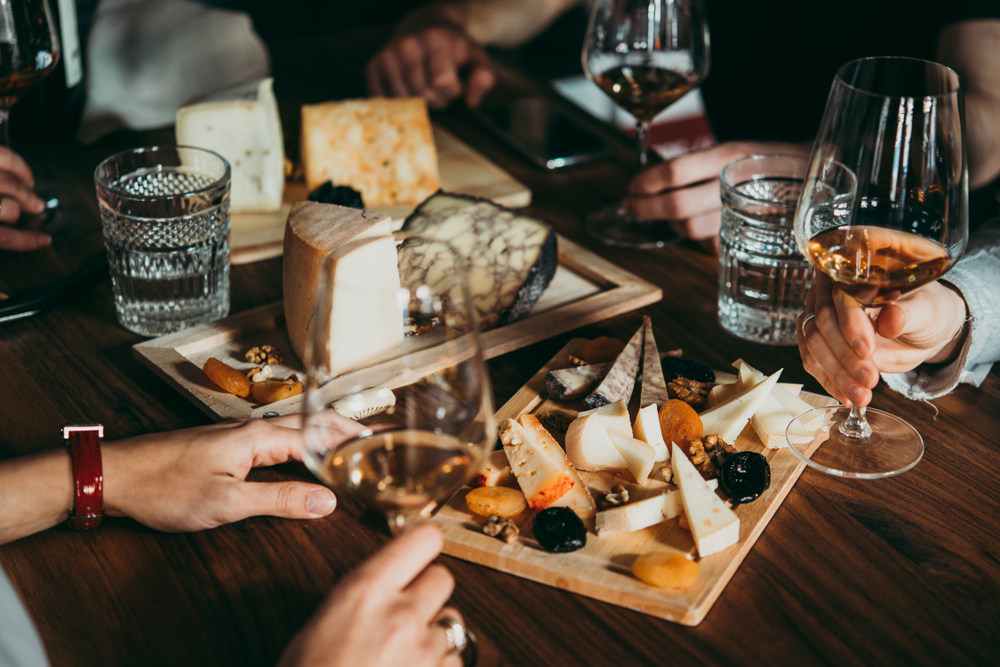 friends-holding-wine-glasses-over-some-cheeseboards.jpg